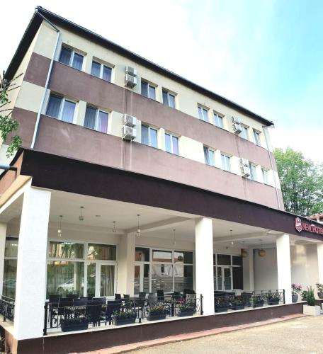 a building with tables and chairs in front of it at Hotel New in Baia Mare