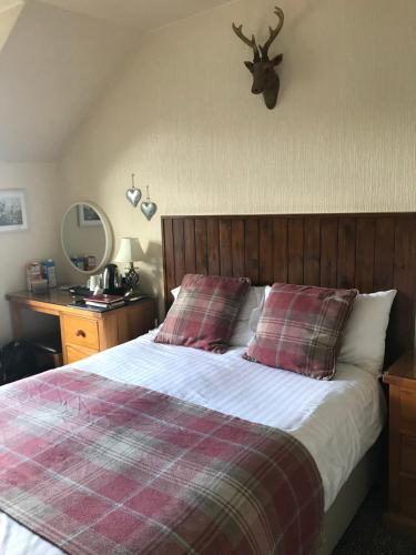 a bedroom with a bed with a deer head on the wall at Foyers Roost in Foyers