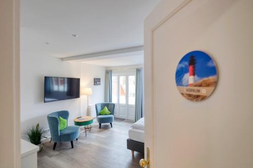 a living room with a room with a bed and a room with a room at Fitschen am Dorfteich in Wenningstedt