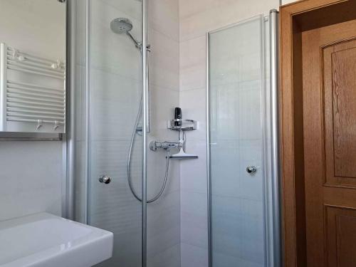 een badkamer met een douche en een glazen deur bij Ferienwohnung Blumenau in Schmallenberg