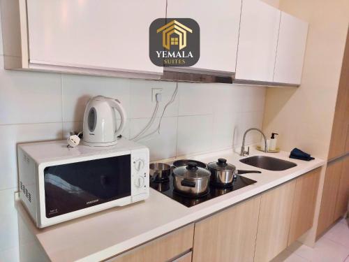 a microwave oven sitting on top of a kitchen counter at Yemala Suites at Skyloft - Johor in Johor Bahru