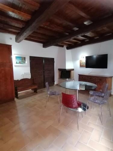 ein Wohnzimmer mit einem Tisch und Stühlen sowie einem TV in der Unterkunft La Marchesina in Ronciglione