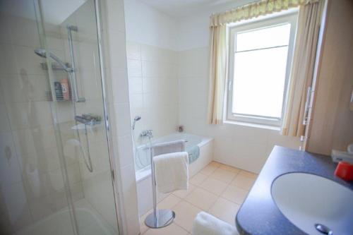 a bathroom with a shower and a sink and a tub at Privatzimmervermietung Margit in Waidhofen an der Ybbs