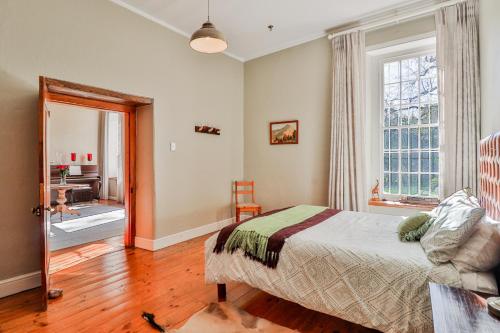 1 dormitorio con cama, ventana y escritorio en Twistniet BnB, en Wellington