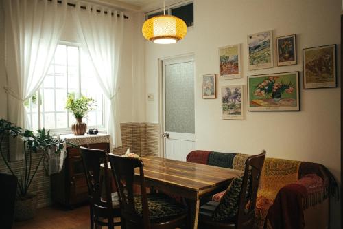 a dining room with a wooden table and chairs at Art Garden Dalat in Da Lat