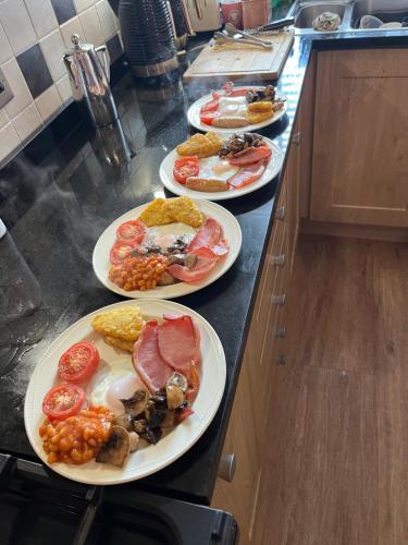 three plates of food on a counter in a kitchen at Autumn Leaves Guest House in Windermere
