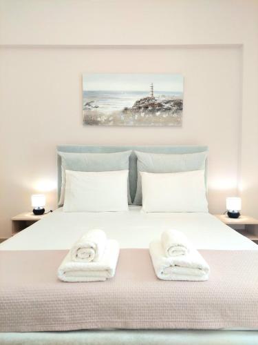 Un dormitorio con una cama blanca con toallas. en Elizabeth Apartments Himare, en Himare