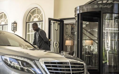a man standing at the door of a car at Four Seasons Hotel The Westcliff in Johannesburg