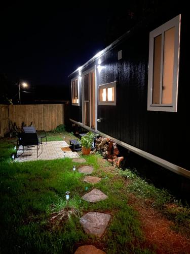 a house with lights on the side of it at night at Little Lodge - Luxury Tiny Home Stay in Alstonville