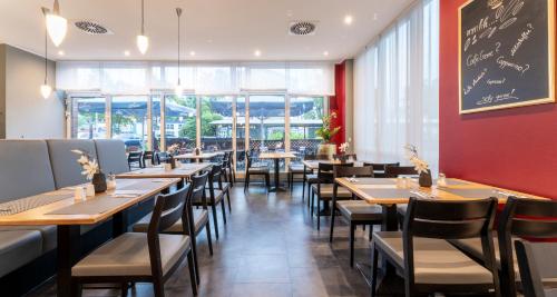 a dining room with tables and chairs and a chalkboard at PLAZA Premium Köln in Cologne