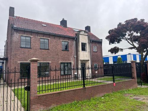a large brick house with a black fence at Kess Maison, Gehele villa met SAUNA en dakterras Enschede in Enschede