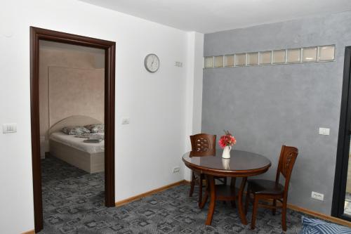 a room with a table and chairs and a bed at Apartament Luxury - Promenada Mall in Craiova