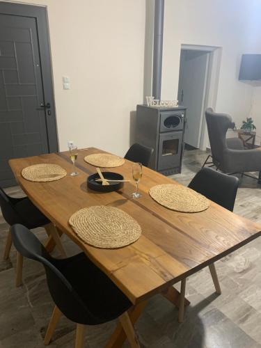 a wooden table with four chairs and wine glasses on it at Eucalyptοs house in Lefkogeia