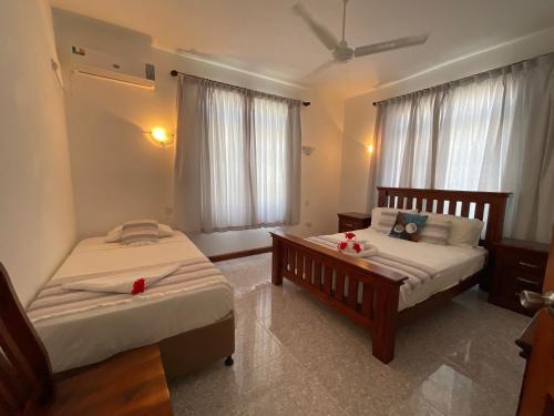 a bedroom with two beds and a window at Didi's Dream apartments in Anse Kerlan