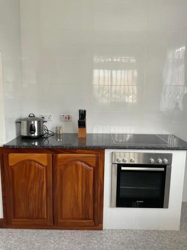 a kitchen with a stove and a microwave at Didi's Dream apartments in Anse Kerlan