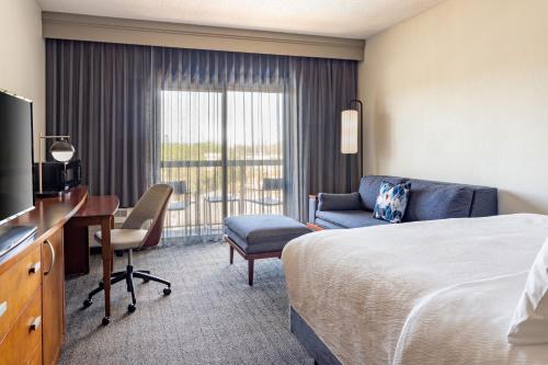 a hotel room with a bed and a desk and a television at Courtyard Tampa Westshore/Airport in Tampa