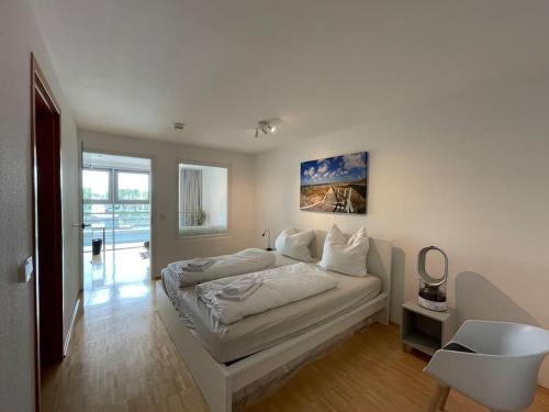 a white bedroom with a bed and a mirror at Bremen Weser Best View Apartment in Bremen