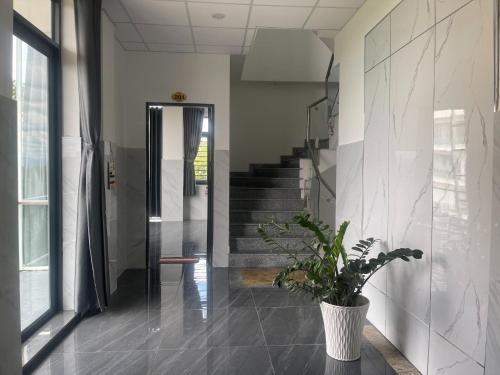 a hallway with a staircase and a potted plant at Ánh Mai Hotel in Bảo Lộc