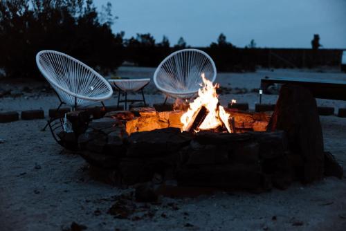 ジョシュア・ツリーにあるJoshua Tree Village Campground - Glamping Retreatの砂の中の椅子2脚と火台