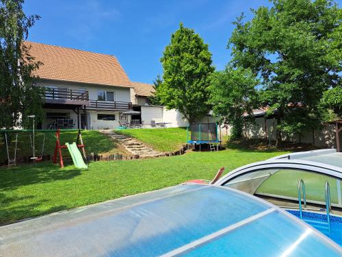 a car parked in front of a house with a playground at Rekreační Domek Litenčice na Jižní Moravě in LitenÄice