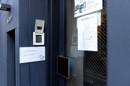 a door with two cell phones on a wall at Cafe & Guest House Nagonoya in Nagoya