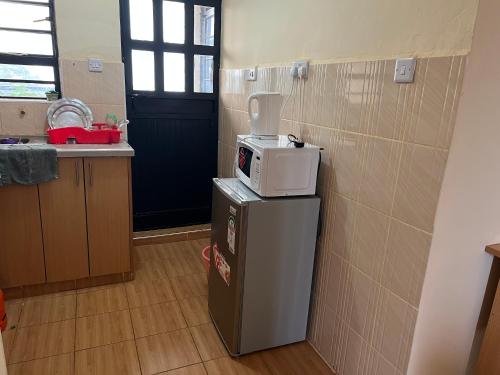 a kitchen with a microwave on top of a refrigerator at Citypal Apartments in Meru