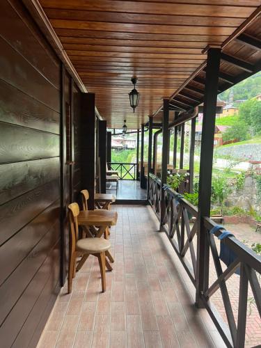 Camili的住宿－Macahel dağ evi，一个带椅子的门廊和木制天花板