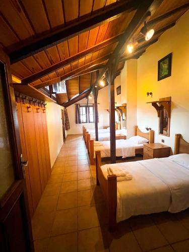Camili的住宿－Macahel dağ evi，一间设有四张床的客房,位于一个设有天花板的房间