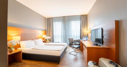 a hotel room with a bed and a television at PLAZA Premium Köln in Cologne