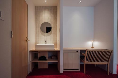 a bathroom with a sink and a desk with a mirror at 無垢　入船の宿 in Kure