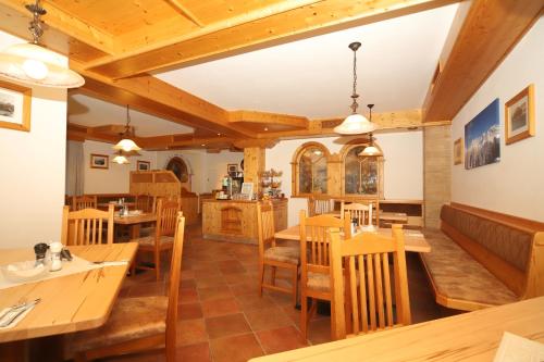 een eetkamer met houten tafels en stoelen bij Hotel Cafe' Hermann in Schladming
