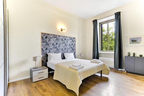 a white bedroom with a bed and a window at Appartamento Napoli 25 - Affitti Brevi Italia in Milan