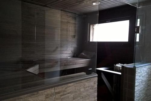 a bathroom with a glass shower with a window at Omakotitalo Vierumäellä X A house near Vierumäki sports center in Heinola