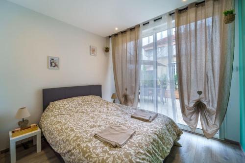 - une chambre avec un lit et une grande fenêtre dans l'établissement Maison calme avec terrasse/garage centre-ville C, à Dijon