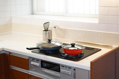 a stove top with a pot and a bowl on it at 青嵐ペンション海まで50M Pension Seiran is only 50m from the coast in Isa