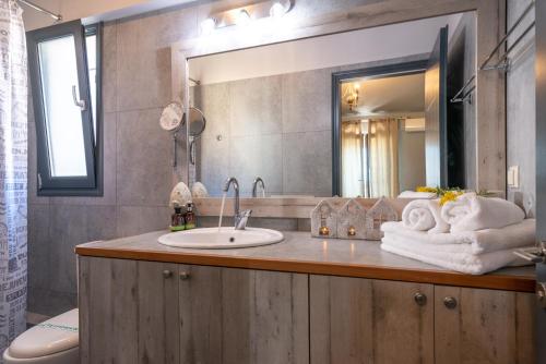 a bathroom with a sink and a mirror at Sagiada Homes in Sagiada
