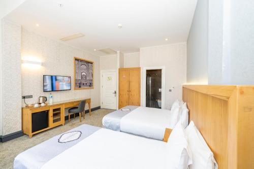 a hotel room with two beds and a desk at Premist Hotels Taksim in Istanbul