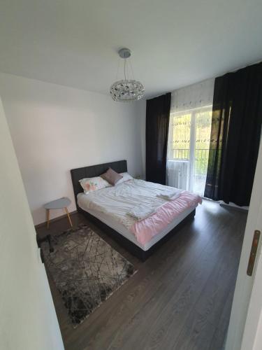 1 dormitorio con cama y lámpara de araña en meda's apartament, en Floreşti