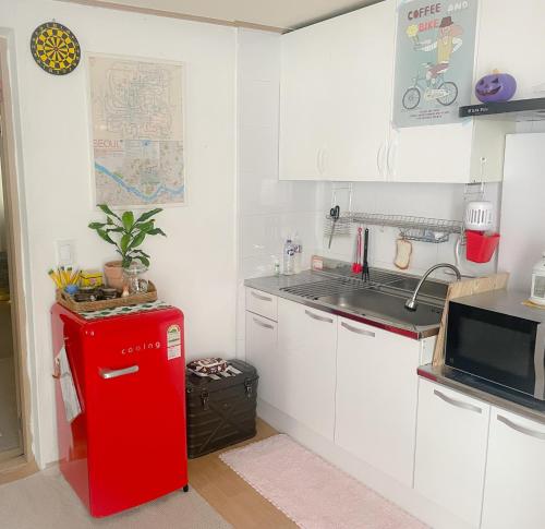 a small kitchen with a red refrigerator and a sink at ARMYCasa with 2 rooms and 1 bathroom in Seoul