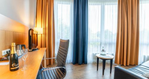 a hotel room with a desk with a bottle of wine at PLAZA Premium Köln in Cologne