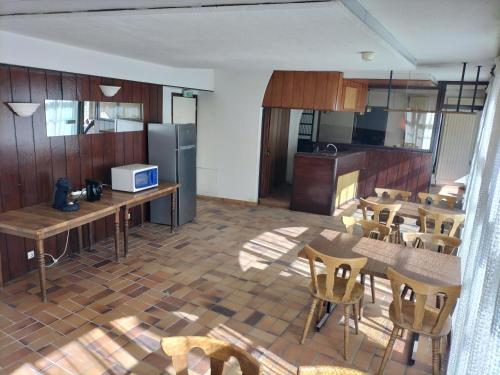 uma cozinha com armários de madeira e uma mesa e cadeiras em Chambre Triple avec Salle de Bains Privative 2 em Vallouise