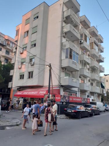 un grupo de personas cruzando una calle frente a un edificio en Beach apartment durres, en Durrës