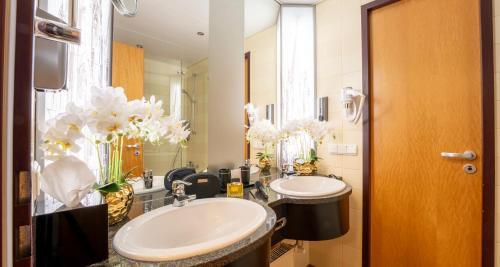 a bathroom with two sinks and a mirror at PLAZA Premium Köln in Cologne