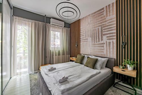 een slaapkamer met een groot bed en een groot raam bij Synagogue Central Kira Apartment in Boedapest