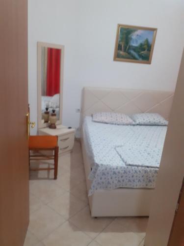 1 dormitorio blanco con 1 cama y 1 silla en Beach apartment durres, en Durrës