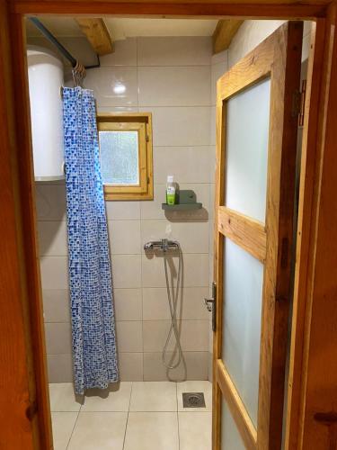 a bathroom with a shower with a blue shower curtain at Vikendica Milošević in Arandjelovac