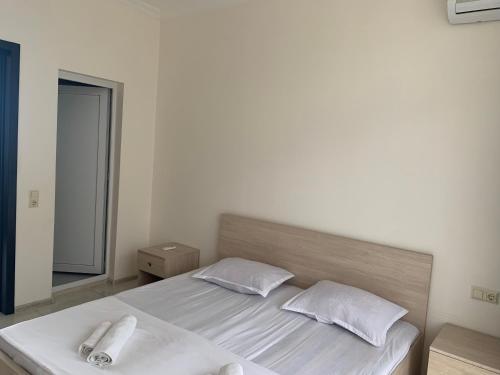 a bed with two white pillows and a mirror at Kobuleti 424 in K'obulet'i