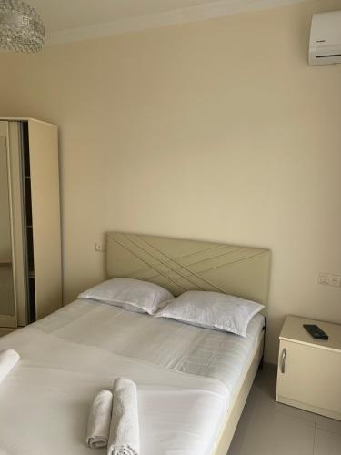 a bedroom with a white bed with two towels on it at Kobuleti 424 in K'obulet'i