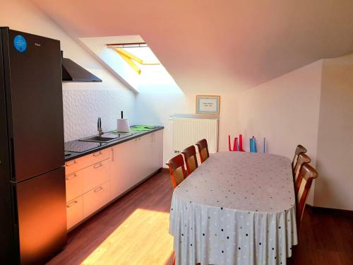 a kitchen with a table with chairs and a refrigerator at Pokoje Gościnne w WSE in Białystok