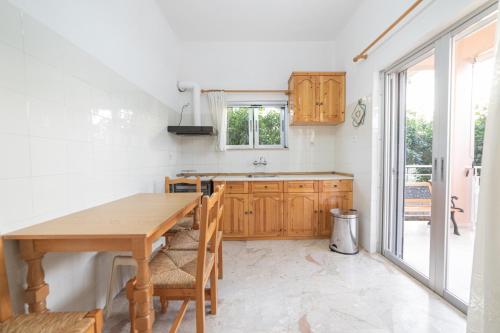 cocina con mesa de madera y fregadero en Olive Apartments Elaionas, en Eleonas